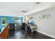 Workspace with hardwood floors, natural lighting, and a large TV in the background at 14910 Northwood Village Ln, Tampa, FL 33613