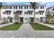 Attractive row of three-story townhomes with grey garages, tasteful landscaping, and tree-lined walkway at 1623 Sea Haven Dr # 307, Punta Gorda, FL 33950