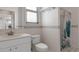 Bright bathroom features a single sink vanity, toilet, and shower with decorative curtain at 17807 Crystal Cove Pl, Lutz, FL 33548