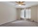Empty bedroom features neutral carpeting, light walls, large windows, and a ceiling fan at 17807 Crystal Cove Pl, Lutz, FL 33548