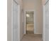 Hallway leading into primary bathroom with large bathtub, tile flooring, and natural light at 17807 Crystal Cove Pl, Lutz, FL 33548