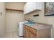 Bright laundry room features a washer, cabinets, sink, and shelf storage at 17807 Crystal Cove Pl, Lutz, FL 33548