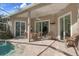 Inviting screened in pool area with covered patio, lush landscaping, and sliding glass doors at 17807 Crystal Cove Pl, Lutz, FL 33548