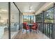 Screened balcony with ceiling fan, table and comfortable red chairs, next to sliding glass door at 1800 Mariner Dr # 11, Tarpon Springs, FL 34689