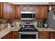 The kitchen features granite countertops, stainless steel appliances and a cooktop at 1824 Clearbrooke Dr, Clearwater, FL 33760
