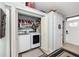 Functional laundry room with washer, dryer, shelving, and extra storage space at 1824 Clearbrooke Dr, Clearwater, FL 33760