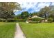 Well-manicured lawn leads to a clubhouse with mature trees enhancing this community gathering space at 1824 Clearbrooke Dr, Clearwater, FL 33760
