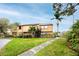 Inviting two-story home with lush lawn, mature trees, and well-maintained landscaping on a sunny corner lot at 1824 Clearbrooke Dr, Clearwater, FL 33760