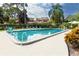 Large community swimming pool with lounge chairs, lush landscaping, and inviting clear water at 1824 Clearbrooke Dr, Clearwater, FL 33760