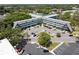 Overhead shot of a distinctive building surrounded by trees, with a parking area at 2042 Australia W Way # 6, Clearwater, FL 33763