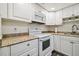 Clean kitchen featuring white appliances, plenty of cabinet space, and granite countertops at 2042 Australia W Way # 6, Clearwater, FL 33763