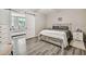 This main bedroom boasts modern gray wood-look floors, and is adorned with neutral decor at 2042 Australia W Way # 6, Clearwater, FL 33763