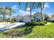 Charming single-story home with a well-manicured lawn, lush landscaping, and a two-car garage, framed by swaying palm trees and blue sky at 2082 Sifield Greens Way # 3, Sun City Center, FL 33573