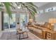 Well-lit living room featuring a leather couch, ceiling fan, and sliding glass doors to the patio at 2082 Sifield Greens Way # 3, Sun City Center, FL 33573