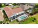 Aerial view of the house with a screen enclosed pool and jacuzzi in lush green backyard and mature landscaping at 2233 Golf Manor Blvd, Valrico, FL 33596