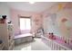 Sweet Bedroom with whimsical mural, crib, daybed, glider and white shelving at 2233 Golf Manor Blvd, Valrico, FL 33596