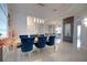 Elegant dining room with modern lighting, blue velvet chairs, and an open view to the backyard at 2233 Golf Manor Blvd, Valrico, FL 33596