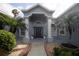 Inviting front entrance with palm trees, decorative columns, and well-maintained landscaping at 2233 Golf Manor Blvd, Valrico, FL 33596