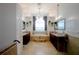 Luxurious main bathroom with a soaking tub, dual vanities, and a stylish chandelier at 2233 Golf Manor Blvd, Valrico, FL 33596