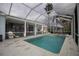 View of in-ground swimming pool with white enclosure, outdoor lighting, and landscaped yard at 2233 Golf Manor Blvd, Valrico, FL 33596