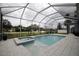 An in-ground swimming pool and spa combination with a white enclosure and white tile surround at 2233 Golf Manor Blvd, Valrico, FL 33596