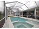 View of the in-ground swimming pool and spa combination with a white enclosure and landscaping at 2233 Golf Manor Blvd, Valrico, FL 33596