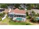 Aerial view of a screened-in pool and jacuzzi surrounded by lush landscaping, backing up to other homes at 2233 Golf Manor Blvd, Valrico, FL 33596