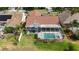 Aerial view of a screened-in pool and jacuzzi surrounded by lush landscaping and well-kept backyard at 2233 Golf Manor Blvd, Valrico, FL 33596