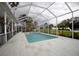 A view of the in-ground pool with white surround and screen enclosure with cloudy sky above at 2233 Golf Manor Blvd, Valrico, FL 33596