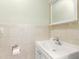 Compact bathroom features a white vanity with sink and mirror, complemented by tiled walls and a toilet paper holder at 238 Sun Ketch Ct # 95, Treasure Island, FL 33706