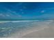 Sandy beach with gentle waves and clear blue sky, perfect for relaxation at 238 Sun Ketch Ct # 95, Treasure Island, FL 33706