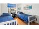 Bright bedroom with hardwood floors, twin beds, and a window overlooking the outdoor area with a view at 238 Sun Ketch Ct # 95, Treasure Island, FL 33706