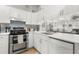 Bright kitchen featuring white cabinets, stainless steel appliances, modern countertops, and a decorative backsplash at 238 Sun Ketch Ct # 95, Treasure Island, FL 33706