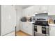 Bright kitchen with white cabinets, stainless steel appliances, and a mosaic tile backsplash that adds color at 238 Sun Ketch Ct # 95, Treasure Island, FL 33706