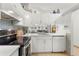 Well-lit kitchen featuring white cabinetry, stainless steel appliances, and an open view into the living room at 238 Sun Ketch Ct # 95, Treasure Island, FL 33706