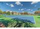 Community tennis court with shade trees and a bright, sunny sky at 238 Sun Ketch Ct # 95, Treasure Island, FL 33706