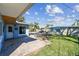 The backyard features a brick paver patio, a grassy area, mature trees, a fence, and a swimming pool at 2451 Baywood W Dr, Dunedin, FL 34698
