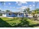 A backyard featuring a swimming pool, patio, and well-maintained lawn at 2451 Baywood W Dr, Dunedin, FL 34698