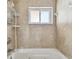 Bathroom featuring a tiled shower with a window and shelving at 2451 Baywood W Dr, Dunedin, FL 34698