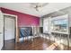 Bedroom with hardwood floors, ceiling fan, window, and colorful accent wall undergoing repairs at 2451 Baywood W Dr, Dunedin, FL 34698