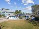 Exterior front elevation of home with solar panels, a one car garage, and green lawn at 2451 Baywood W Dr, Dunedin, FL 34698