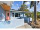 The front entrance features a stone garden and a unique salmon-colored door at 2451 Baywood W Dr, Dunedin, FL 34698