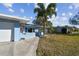 Single-story home with a well-manicured lawn and mature trees at 2451 Baywood W Dr, Dunedin, FL 34698