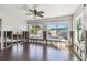 Living room with wood floors, ceiling fan, and natural light streaming through windows at 2451 Baywood W Dr, Dunedin, FL 34698