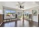Bright living room featuring wood floors, ceiling fan, and natural light from multiple windows at 2451 Baywood W Dr, Dunedin, FL 34698