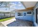 Back patio of blue home with windows and fenced yard at 2451 Baywood W Dr, Dunedin, FL 34698