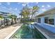 Relaxing backyard pool with a brick paver deck, surrounded by mature trees and a wooden fence at 2451 Baywood W Dr, Dunedin, FL 34698