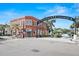 Historic building featuring brick facade, mature palm trees, and visitor parking at 277 Ashley Ct, Dunedin, FL 34698