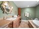 Bathroom with detailed vanity, patterned tile floors, and a soaking tub for relaxation at 2906 Pemberton Creek Dr, Seffner, FL 33584