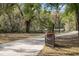 Long driveway with trees lining the side that leads through a metal gate to the property at 2906 Pemberton Creek Dr, Seffner, FL 33584